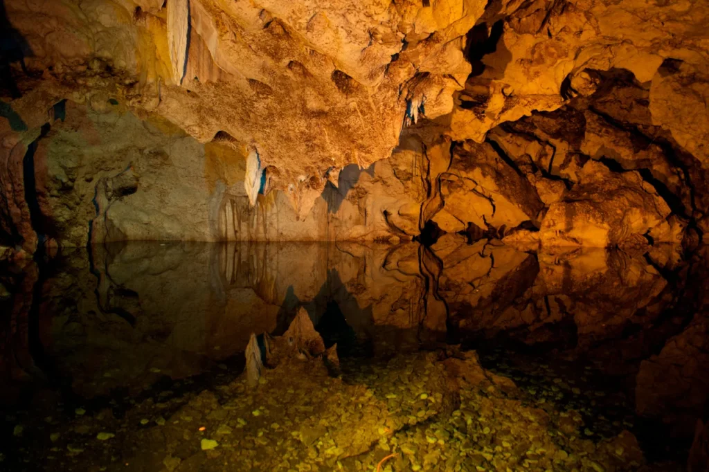 Illuminated rock formations inside Green Grotto Caves