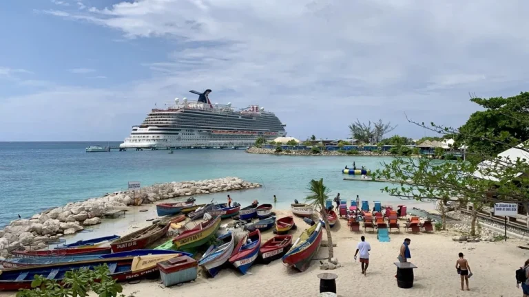 Fishing boats on an Ocho Rios beach with a cruise ship offshore