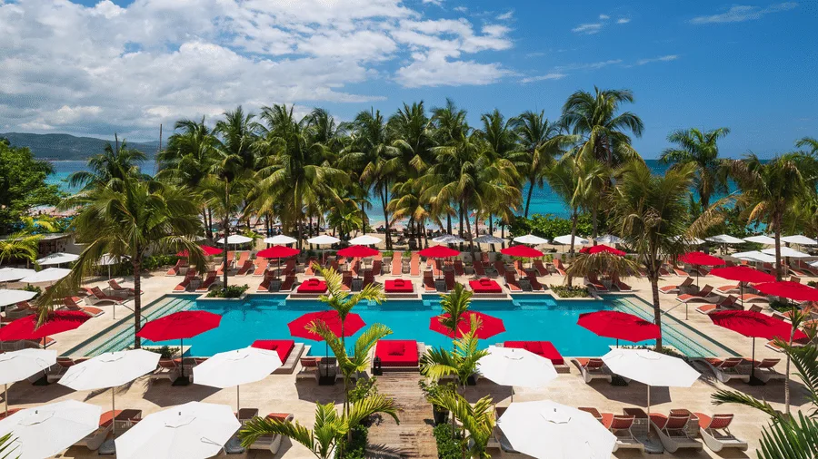 Poolside lounge chairs and umbrellas at S Hotel Montego Bay
